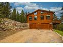 Beautiful log cabin with a two-car garage, rock wall landscaping, and second story deck at 310 Wendelyn Way, Boulder, CO 80302
