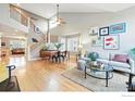 Open living space with hardwood floors, vaulted ceilings, staircase, and contemporary furnishings at 3235 Basalt Ct, Superior, CO 80027