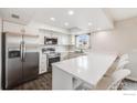 Bright kitchen features stainless steel appliances, counter seating and modern fixtures at 3964 S Yosemite St, Denver, CO 80237