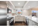 Bright kitchen featuring stainless steel appliances, counter seating and modern fixtures at 3964 S Yosemite St, Denver, CO 80237