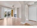 Open-concept living room with hardwood floors, a ceiling fan, fireplace, and large windows at 4500 Baseline Rd # 3203, Boulder, CO 80303