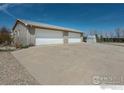 Spacious four-car garage with concrete driveway and ample parking at 524 E County Road 8, Berthoud, CO 80513