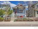 Charming blue two-story home with a cozy front patio and beautifully landscaped front yard at 541 Hoyt Ln, Lafayette, CO 80026