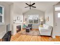 Bright living room with fireplace, hardwood floors, and large windows with plantation shutters at 541 Hoyt Ln, Lafayette, CO 80026