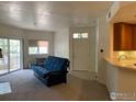 Cozy living room with a sliding door to a balcony, carpeting, and a breakfast bar with sink at 560 Mohawk Dr # 35, Boulder, CO 80303