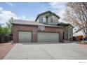 Beautiful two-story home with a three-car garage, brick detailing, and a basketball hoop, set against a backdrop of mature trees at 5832 E Wetlands Dr, Frederick, CO 80504