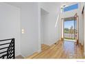 Bright entryway with hardwood floors, modern light fixture, and an open view of the front yard at 603 Mountain Dr, Longmont, CO 80503