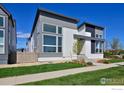 Contemporary home with large windows and a landscaped front yard, set against a clear blue sky at 603 Mountain Dr, Longmont, CO 80503