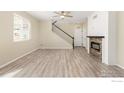 Open concept living space with modern electric fireplace and stylish staircase at 6131 Easton Cir, Frederick, CO 80504