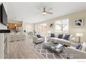 Bright living room with a large rug, a ceiling fan, and dining space adjacent to the kitchen at 6131 Easton Cir, Frederick, CO 80504