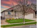 Inviting home with a well-kept front yard, stone accents, and an attached two-car garage at 6659 12Th St, Frederick, CO 80530