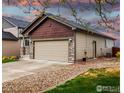 Attached two-car garage with stone detailing and easy access to the home's side entrance at 6659 12Th St, Frederick, CO 80530
