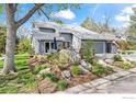 Attractive gray home with a 2-car garage and a professionally landscaped yard with boulders and flowers at 7126 Cedarwood Cir, Boulder, CO 80301