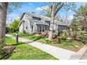 A well-maintained gray home with a manicured lawn and sidewalk creates an inviting curb appeal at 7126 Cedarwood Cir, Boulder, CO 80301