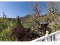 Picturesque backyard featuring a charming treehouse nestled among lush greenery and a view of the Flatirons at 838 University Ave, Boulder, CO 80302