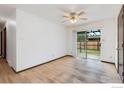 Bedroom with hardwood floors, a ceiling fan, and sliding glass doors to the backyard at 9 Seattle Ln, Longmont, CO 80501