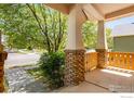 Charming covered front porch with brick and column detailing at 1038 Village Cir, Erie, CO 80516