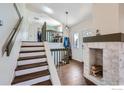 Inviting entryway features hardwood floors, exposed brick, and staircase at 10440 W 83Rd Ave, Arvada, CO 80005