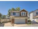 Charming two-story house with gray garage door and manicured landscaping at 10440 W 83Rd Ave, Arvada, CO 80005