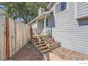 Exterior shot showcasing a welcoming entrance with wooden stairs and flower bed at 10440 W 83Rd Ave, Arvada, CO 80005