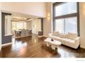 Bright living room featuring hardwood floors, large windows, and a modern sofa at 10583 Oakmoor Cir, Parker, CO 80134