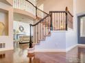 Elegant foyer showcases a staircase with wrought iron railing and gleaming hardwood floors at 10583 Oakmoor Cir, Parker, CO 80134