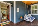 Inviting front porch with a porch swing, dark siding, white trim, and a welcoming entrance at 1121 Lincoln Ave, Louisville, CO 80027