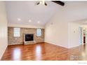 Comfortable living room with brick fireplace, ceiling fan, and hardwood floors at 130 Ash St, Hudson, CO 80642