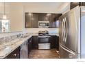 Modern kitchen with stainless steel appliances, granite countertops, and dark cabinetry at 1320 Kestrel Ln # E, Longmont, CO 80501