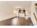 Open-concept living room featuring hardwood floors, recessed lighting and a view into the kitchen at 1320 Kestrel Ln # E, Longmont, CO 80501
