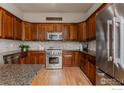 Well-equipped kitchen featuring stainless steel appliances and granite countertops at 13360 W 83Rd Pl, Arvada, CO 80005