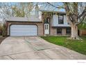 Charming two-story home with a brick facade, well-maintained lawn and a spacious two-car garage at 13755 W 65Th Dr, Arvada, CO 80004