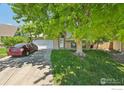 Charming brick home with well-maintained lawn, mature tree, and two-car garage at 13755 W 65Th Dr, Arvada, CO 80004