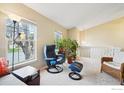 Cozy living room featuring large windows and comfortable seating with multiple plants at 13755 W 65Th Dr, Arvada, CO 80004
