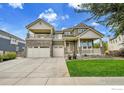 Stunning two-story home featuring a stone facade, multi-car garage, and manicured lawn at 16060 Fairway Dr, Commerce City, CO 80022