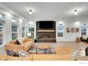 Inviting living room featuring a fireplace, a large television, comfortable seating, and lots of natural light at 16060 Fairway Dr, Commerce City, CO 80022
