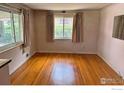 Bright living room features gleaming hardwood floors and large windows offering ample natural light at 1633 S Alcott St, Denver, CO 80219