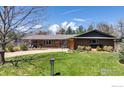 Charming single story brick home featuring a manicured lawn and mature trees in a desirable neighborhood at 205 Lipan Way, Boulder, CO 80303