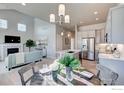 Open-concept living space with a kitchen, dining area, and living room with fireplace at 208 High Point Dr, Longmont, CO 80504