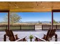 Inviting covered back porch with chairs offers beautiful views of the mountains and surrounding landscape at 2139 S County Road 15, Berthoud, CO 80513