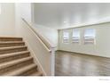 Bright living room featuring a staircase and large windows providing plenty of natural light at 2231 Crosswind St, Fort Lupton, CO 80621