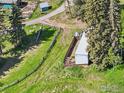 Aerial view of charming property featuring a shed, fencing and beautiful green surroundings at 27921 Alabraska Ln, Evergreen, CO 80439