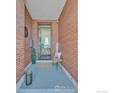 Charming home entrance featuring brick walls, a 'WELCOME' sign, and a cozy chair at 2890 Curtis St, Denver, CO 80205
