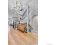 Open entryway showcasing hardwood floors, modern light fixture, and staircase with sleek iron railings at 2890 Curtis St, Denver, CO 80205