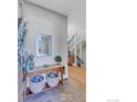 Elegant foyer with stylish console table, mirror, and open staircase with modern railing at 2890 Curtis St, Denver, CO 80205