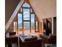 Living room with stunning views, floor to ceiling windows, wood burning stove, and hardwood floors at 291 Canon View Rd, Boulder, CO 80302