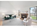 Inviting living room with a cozy fireplace, large windows offering scenic views, and a comfortable seating arrangement at 3550 Smuggler Cir, Boulder, CO 80305
