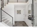 Bright entryway featuring neutral tile flooring, open staircase, and modern accents at 3809 Howe Ct, Boulder, CO 80301