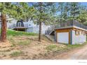 Hillside view of a distinctive dome home with a detached garage accessible via a stone staircase at 387 Millionaire E Dr, Boulder, CO 80302