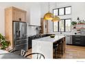Modern kitchen features custom cabinets, stainless appliances, and a spacious island with seating at 4046 Niblick Dr, Longmont, CO 80503